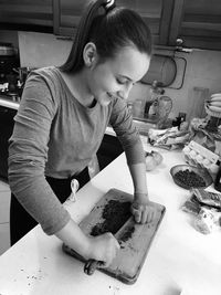 Close up of young girl preparing food, chocolate cake.indoor kitchen black and white