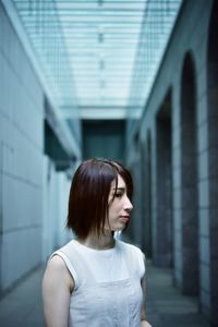 Portrait of woman standing against built structure