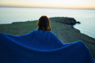 Rear view of woman relaxing on beach