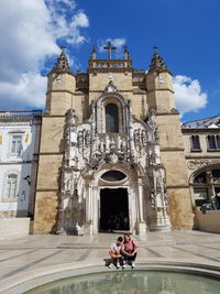 People in front of historic building against sky