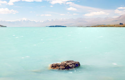Scenic view of  turquoise water in lake tekapo against sky