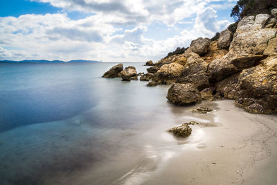 Rocks on beach against sky