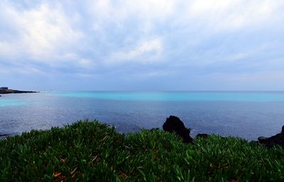 Scenic view of sea against cloudy sky