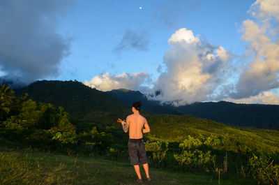 Full length of man standing on field against sky