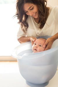 Mother bathing son in bathtub at bathroom