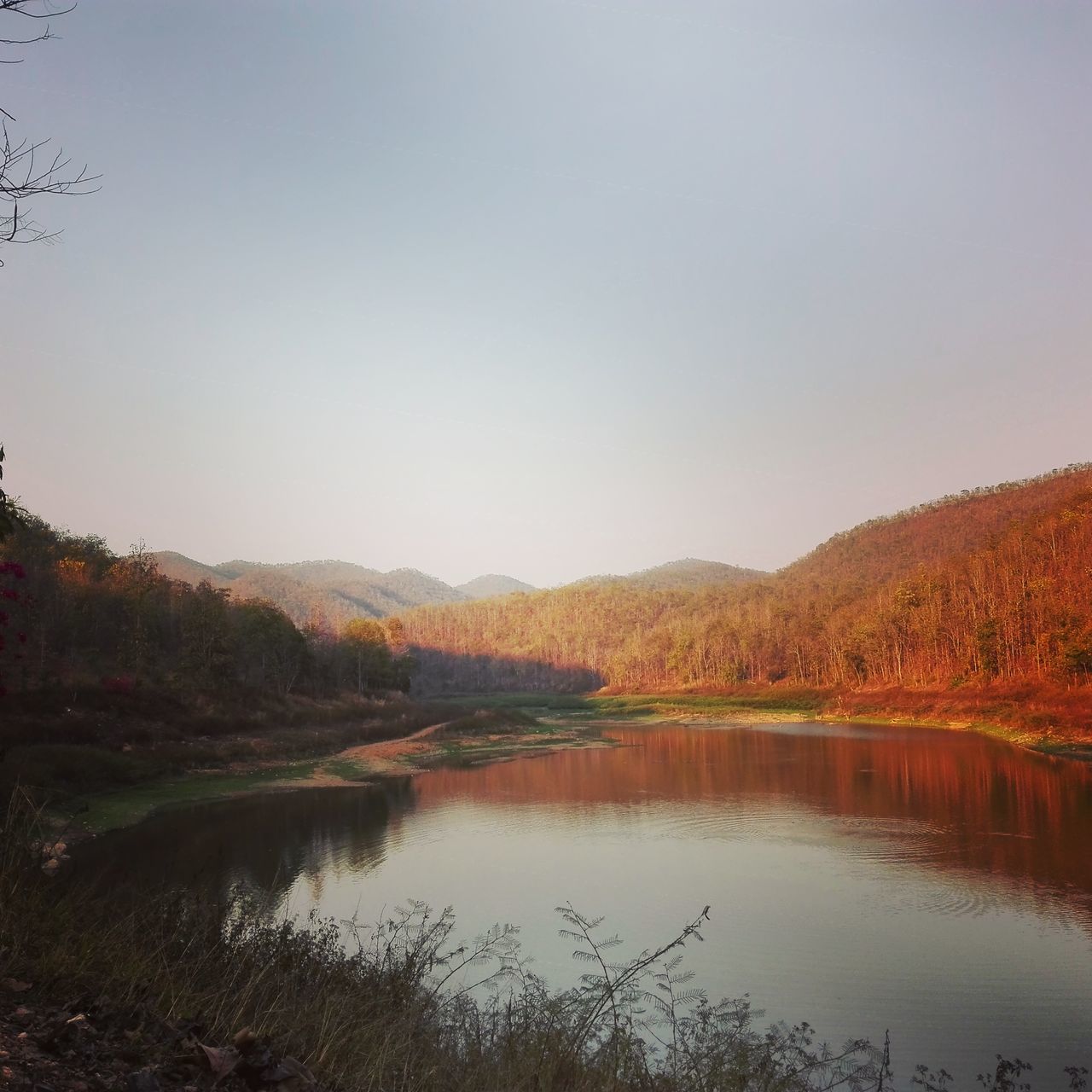 SCENIC VIEW OF CALM LAKE AGAINST MOUNTAIN RANGE