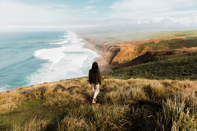 Rear view of woman looking at sea against sky