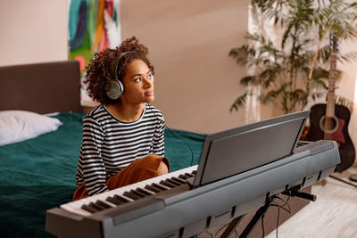 Portrait of smiling young woman using laptop at home