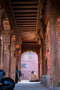 Rear view of people walking in corridor of building