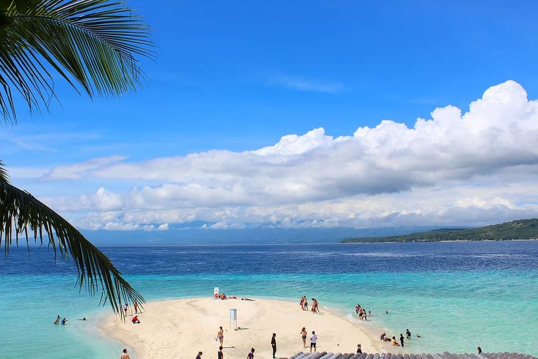 beach, sea, sand, water, beauty in nature, vacations, blue, palm tree, sky, cloud - sky, scenics, nature, tranquil scene, tranquility, tree, horizon over water, summer, outdoors, large group of people, day, travel destinations, relaxation, real people, lifestyles, women, people