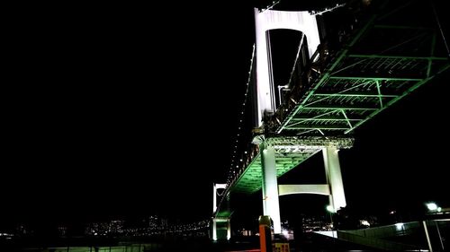 Low angle view of illuminated bridge against sky at night