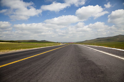 Empty road along countryside landscape