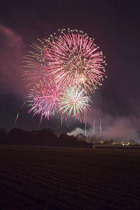 Low angle view of firework display at night