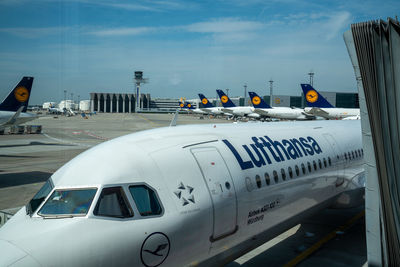 Airplane on airport runway against sky