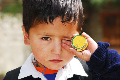 Close-up portrait of boy holding camera