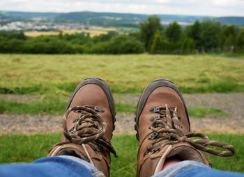 Low section of man wearing shoes on field