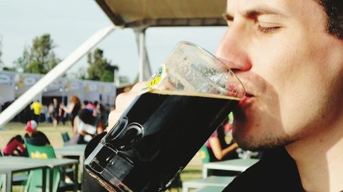 Close-up of man having drink at restaurant outdoors