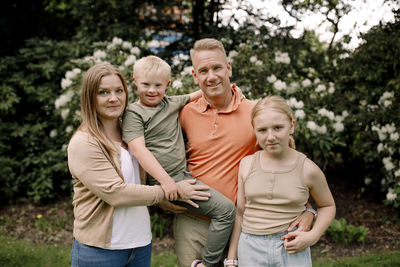 Portrait of smiling family standing at park