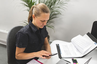 Woman using cell phone in office