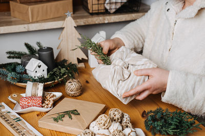 Christmas furoshiki japanese fabric wrapping gifts process. woman wrapping christmas furoshiki zero