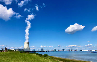 Steam emitting from nuclear power plant against blue sky