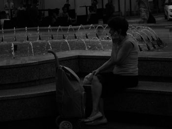 Side view of young woman sitting on chair