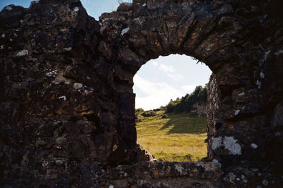 Old ruin seen through hole in rock