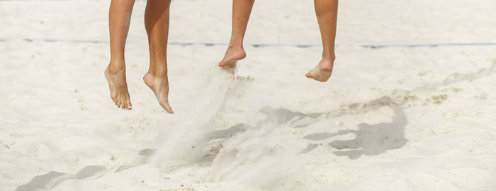 Low section of women playing beach volleyball