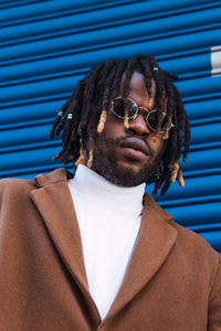 Portrait of young man wearing sunglasses standing outdoors