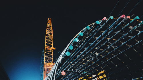 Low angle view of illuminated built structure against sky at night