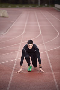 Portrait of confident athlete at starting line