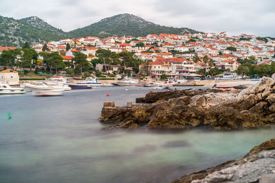 High angle view of townscape by sea against sky