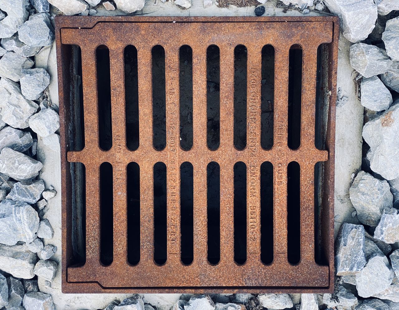 DIRECTLY ABOVE SHOT OF OLD METAL GRATE AGAINST WALL