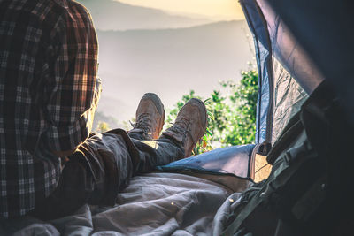 Low section of man relaxing in tent 