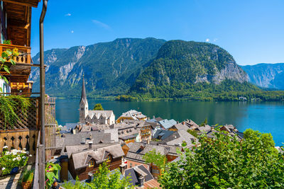 Scenic view of lake by buildings and mountains against sky