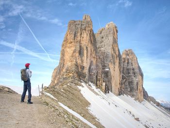 Backpacker on trip around tre cime di lavaredo in sunny april morning. view from tour around massive