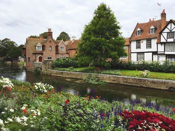 Canal amidst houses and buildings against sky