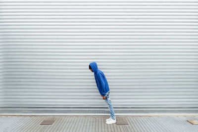 Young man leaning in front of shutter