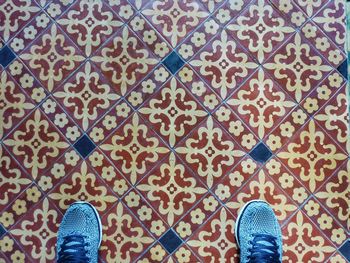 Directly above shot of shoes on patterned tiled floor