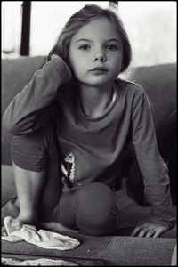 Portrait of boy sitting on sofa at home