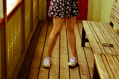Low section of man standing on wooden floor