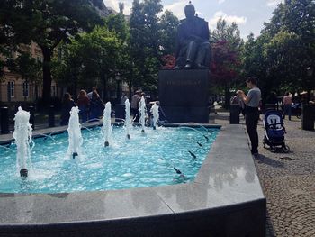 People by swimming pool against sky