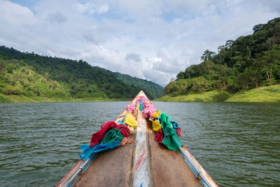 Low section of person tied on boat moored at shore against sky