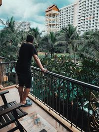 Rear view of man standing by swimming pool