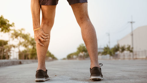 Low section of man standing on footpath