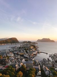 High angle view of city by sea against sky