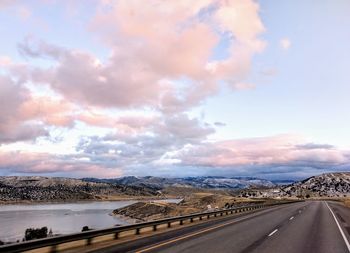 Empty road along landscape against sky