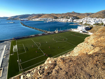 An aerial view of tinos football ground as a youth football match takes place, chora, tinos