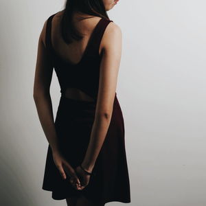 Midsection of woman standing against white background