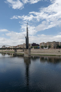 Reflection of building in river against sky